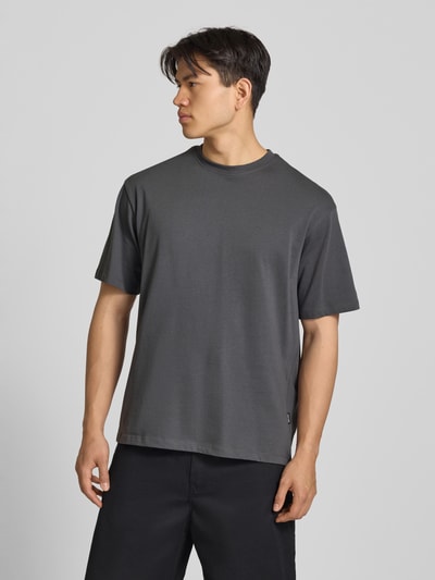 Männermodel trägt Oversized T-Shirt Modell 'FISHER' von Blend in Dunkelgrau, Reine Baumwolle, Rundhalsausschnitt, Ganzkörperansicht von vorne. Rückenlänge bei Größe M: 72 cm.
