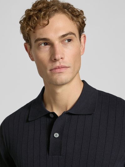 Männermodel trägt Regular Fit Poloshirt aus reiner Baumwolle Modell 'TORINO' von Selected, dunkelblau mit feiner Rippenstruktur, Nahaufnahme Oberkörper, Herren Poloshirt von Selected