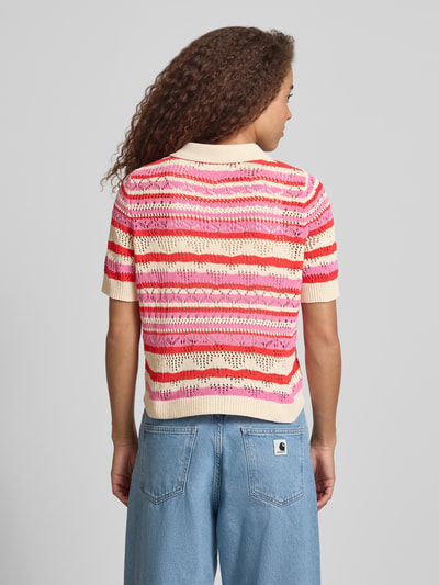 Modelka nosi Regular Fit Poloshirt aus Strick Modell 'LULA' von ONLY, kolorowy wzór w paski, dzianina z ażurem, krótki rękaw, widok całej sylwetki z tyłu.