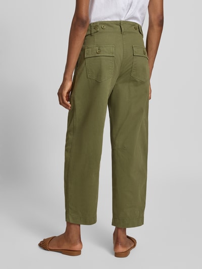 Frauenmodel trägt Barrel Leg Hose aus Baumwoll-Mix Modell 'OCTOBER' von CAMBIO in Olivgrün, Detailaufnahme Ganzkörperansicht Rückansicht. Unifarbene Optik, Barrel Fit, cropped Länge, Bundfalte, seitliche Riegel, Gesäß- und Eingrifftaschen, Gürtelschlaufen.