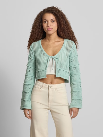 Frauenmodel trägt Regular Fit Strickjacke aus Baumwoll-Mix Modell 'NATALIE' von Only, Optik: Unifarben, Trompetenärmel, Ajour-Strick, Schnürung, Ganzkörperansicht von vorne.