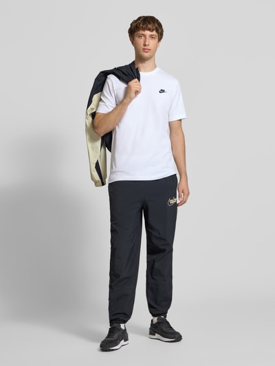 Männermodel trägt T-Shirt mit Label-Stitching von Nike in Weiß aus Reine Baumwolle, Regular-Fit, Rundhalsausschnitt, Ganzkörperansicht von vorne. Rückenlänge bei Größe M: 73 cm.