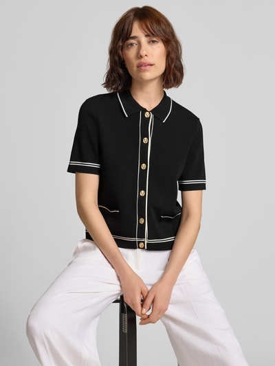 Frauenmodel trägt Cardigan aus Viskose-Mix mit 1/2-Arm von Jake*s Collection in Schwarz mit Kontraststreifen und Knopfleiste, Nahaufnahme Oberkörper.