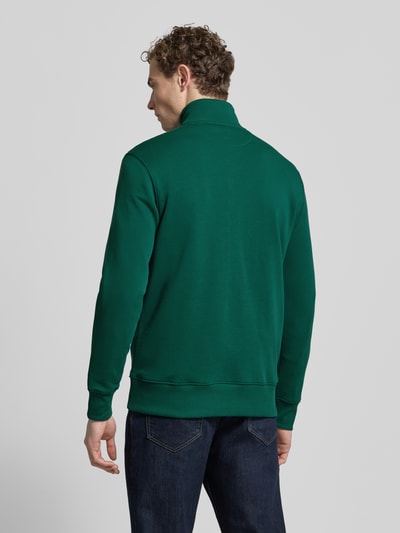 Männermodel trägt Sweatjacke mit Label-Stitching von Gant in Dunkelgrün, Baumwoll-Mix, Stehkragen, Rückenansicht, Ganzkörperansicht Rückansicht.