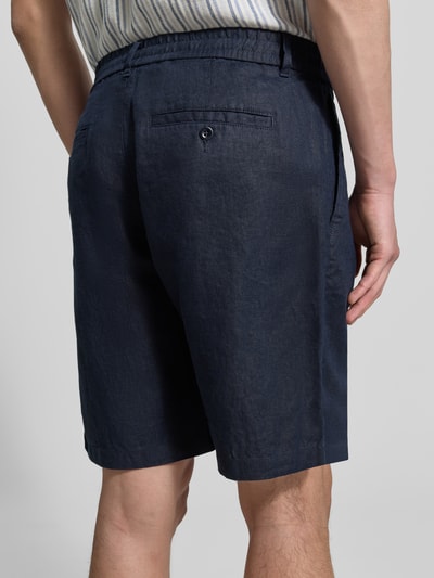 Männermodel trägt Shorts aus Leinen mit Gesäßtaschen von Gant, dunkelblau, Regular-Fit, elastischer Bund, Ganzkörperansicht Rückansicht. Bundweite bei Größe M: 43 cm, Innenbeinlänge 23 cm.