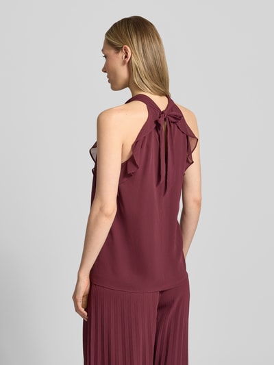 Frauenmodel trägt Top mit Volants und Neckholder von V by Vera Mont in bordeaux, Chiffon, Knotendetail, rückseitiger Cut Out, Ganzkörperansicht Rückansicht.
