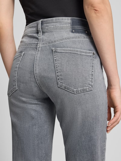 Kobieta nosi Slim Fit Jeans aus Baumwoll-Mix Modell 'PIPER' von CAMBIO, jasnoszary denim, widoczne tylne kieszenie, damskie jeansy slim fit, widok z tyłu, produkt: Damen Slim Fit Jeans von CAMBIO, detal z tyłu.