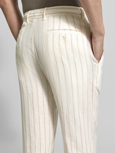 Männermodel trägt Regular Fit Hose aus Leinen-Viskose-Mix von MCNEAL in Creme mit feinen Längsstreifen, Eingrifftaschen, Detailaufnahme Rückansicht. Bundweite bei Größe M: 46 cm, Innenbeinlänge bei Größe M: 84 cm, Gesäßtaschen.