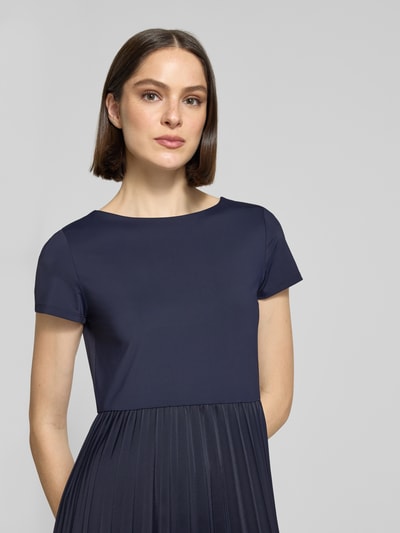 Frauenmodel trägt Midikleid in Plissee-Optik von Christian Berg Woman Selection in Dunkelblau, taillierte Passform, Rundhalsausschnitt, kurze Ärmel, elastischer Material-Mix, Nahaufnahme Oberkörper.