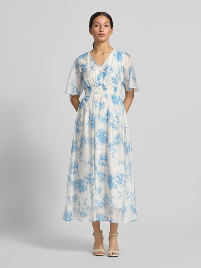 Frauenmodel trägt Midikleid aus Lyocell-Mix Modell 'Evangelia' von MSCH Copenhagen im Allover-Look, blau-weiß, taillierter Schnitt, V-Ausschnitt, Ganzkörperansicht von vorne, Rückenlänge bei Größe S: 131 cm, Brustweite bei Größe S: 41 cm, Ärmellänge bei Größe S: 31 cm.