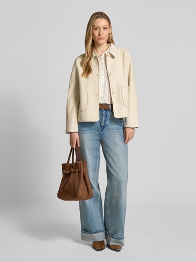 Kobiece model prezentuje kurtkę Jacke mit Umlegekragen Modell 'Yanna' od FREE/QUENT w jasnym kolorze z prostym krojem, wykładanym kołnierzem, listwą guzikową i wpuszczanymi kieszeniami, długość tyłu w rozmiarze S: 56 cm, szerokość ramion w rozmiarze S: 43 cm, szerokość klatki piersiowej w rozmiarze S: 49 cm, długość rękawów w rozmiarze S: 60 cm, widok całej sylwetki z przodu.