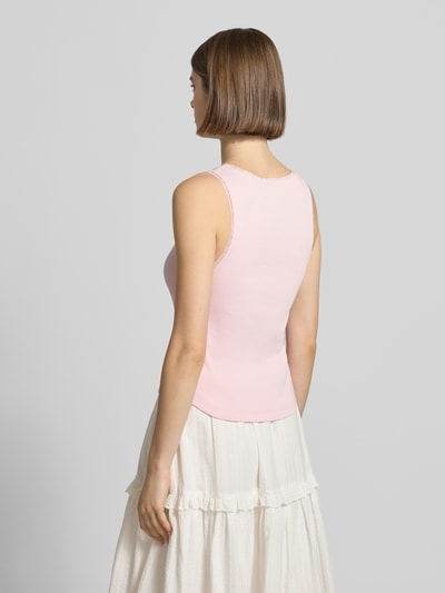 Frauenmodel trägt Tanktop in Ripp-Optik Modell 'Jolie' von OH APRIL, hellrosa, Baumwoll-Elasthan-Mix, Spitzenbesatz, Ganzkörperansicht Rückansicht.