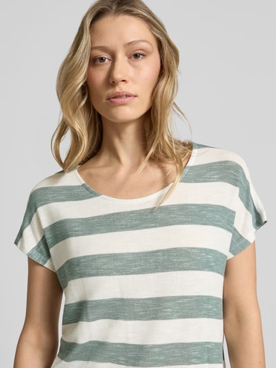 Frauenmodel trägt Regular Fit T-Shirt aus Viskose-Mix Modell 'WIDE STRIPE' von Vero Moda, Mehrfarbig, Streifen-Design, Feinstrick, Label-Stitching-Applikation, U-Boot-Ausschnitt, Kurzarm, abgerundet, Asymmetrisch, Nahaufnahme Oberkörper.