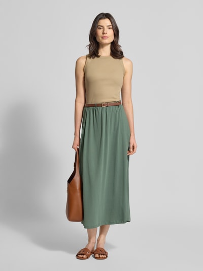 Vrouwenmodel draagt Maxi-Rock aus Baumwoll-Mix Modell 'LUNA' van Vero Moda in effen groen, licht uitlopende fit, jersey textuur, elastische tailleband met riem, maxi-lengte, volledige lichaamsvoorzijde.