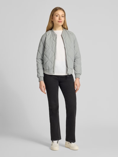 Modelka kobieca ma na sobie jasno-szarą Steppjacke mit Knopfleiste Modell 'ANGE2' od khujo, krój regular fit, widok całej sylwetki z przodu.