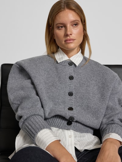Vrouwenmodel draagt gebreid jack van Puur katoen, los model, doorlopende knoopsluiting, ribboorden, Knit Cardigan aus Wolle van Style Icon Collection, ruglengte maat S 46 cm, mouwlengte maat S 58 cm, detailopname bovenlichaam.