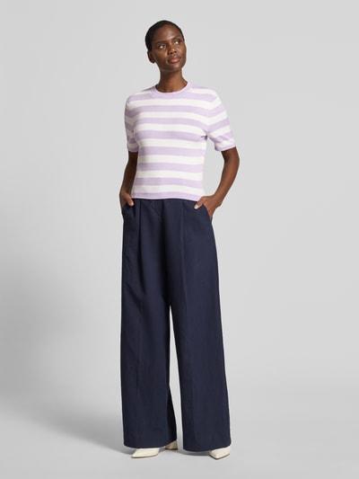 Vrouwenmodel draagt gebreid shirt van viscosemix met stretch van GUIDO MARIA KRETSCHMER WOMAN, slim fit, all-over look, ronde hals, model 'Maria', lila-witte strepen, ruglengte maat 36: 47 cm, mouwlengte maat 36: 23 cm, broek in donkerblauw, lichte schoenen, kleurrijk-simple textuur, voorkant, gehele lichaam.