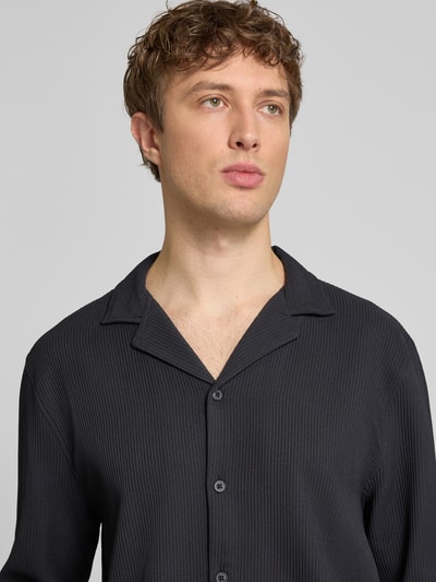 Männermodel trägt Regular Fit Langarmhemd in Plissee-Optik von REVIEW, Schwarz, Material-Mix mit Stretch-Anteil, Nahaufnahme Oberkörper.