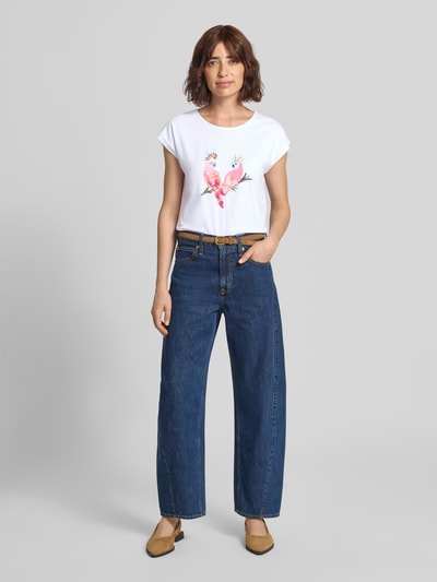 Frauenmodel trägt T-Shirt mit Motiv-Print und Pailletten von MORE & MORE, weiß, Baumwoll-Elasthan-Mix, Ganzkörperansicht von vorne.