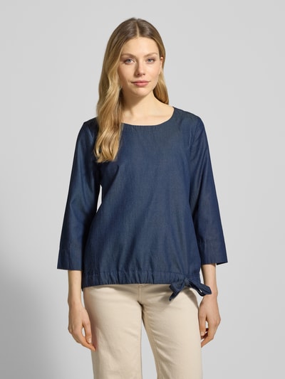 Modelka kobieca nosi Blusenshirt im Denim-Look mit 3/4-Arm od Christian Berg Woman, mieszanka lyocellu i bawełny, krój regular fit, imitacja denimu, okrągły dekolt, rękaw o dł. 3/4, długość tyłu w rozmiarze 36: 63 cm, długość rękawa w rozmiarze 36: 48 cm, ciemnoniebieski, prosta tekstura, przód, zbliżenie na górną część ciała.