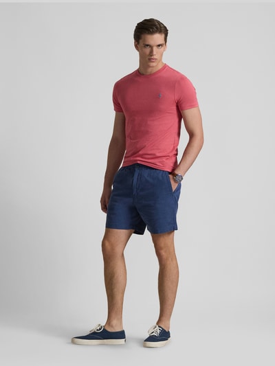 Männermodel trägt Regular Fit T-Shirt aus reiner Baumwolle von Polo Ralph Lauren in Uni-Rot mit Logo-Stitching, Ganzkörperansicht von vorne.