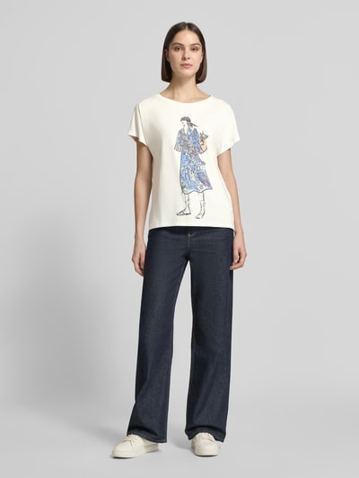 Frauenmodel trägt Damen T-Shirt mit Motiv-Print von Oui aus Baumwoll-Mix mit Modal-Anteil, Relaxed-Fit, Ziersteinbesatz, Rundhalsausschnitt, Rückenlänge bei Größe 36: 59 cm, cremefarben mit blauen, grauen und beigen Akzenten, glatte Textur, Ganzkörperansicht von vorne.