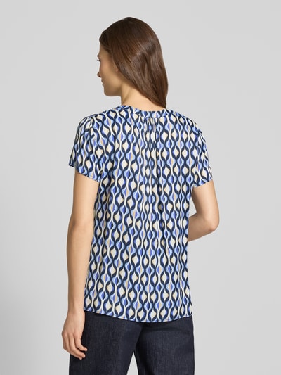 Frauenmodel trägt Blusenshirt aus Viskose im Allover-Look von Betty Barclay, Regular-Fit, kurze Ärmel, geometrisches Muster, Rückenlänge 61 cm, Ganzkörperansicht Rückansicht.