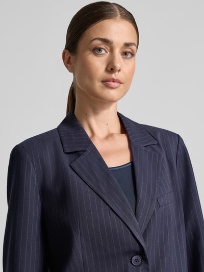 Frauenmodel trägt Regular Fit Blazer mit Viskose-Anteil Modell 'Ryan' von LOLLYS LAUNDRY, dunkelblau mit feinen Streifen, Nahaufnahme Oberkörper. Elastischer Material-Mix, Reverskragen, Knopfleiste, Pattentaschen, Brusttasche.