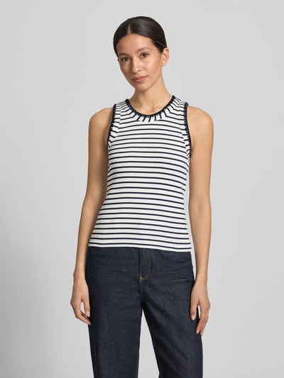 Frauenmodel trägt Tanktop mit Stitchings und Rundhalsausschnitt von Rich & Royal im Baumwoll-Elasthan-Mix, Slim-Fit, Ripp-Optik, Rückenlänge 50 cm, gestreiftes Design in Schwarz-Weiß, Ganzkörperansicht von vorne.
