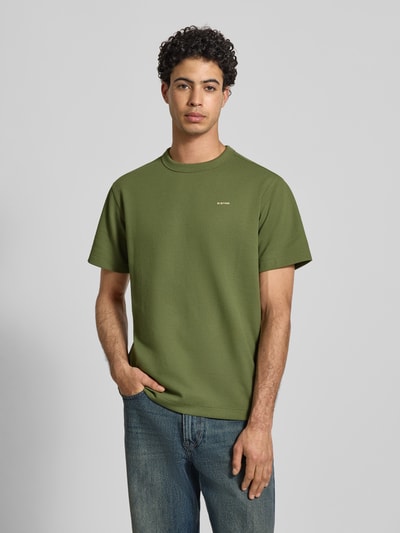 Männermodel trägt Regular Fit T-Shirt mit Strukturmuster von G-Star Raw, grünes Herren T-Shirt mit Rundhalsausschnitt, Logo, Ganzkörperansicht von vorne. Rückenlänge bei Größe M: 71 cm.