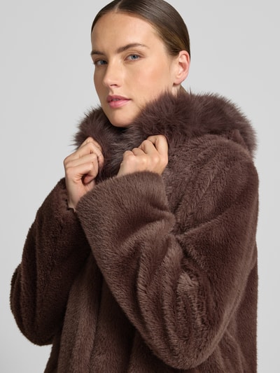 Frauenmodel trägt Mantel aus Kunstfell mit Eingrifftaschen von Marc Cain in Braun, weiche Textur, Regular Fit, Nahaufnahme Oberkörper. Rückenlänge 90 cm, Schulterbreite 39 cm, Brustweite 55 cm, Ärmellänge 63 cm.