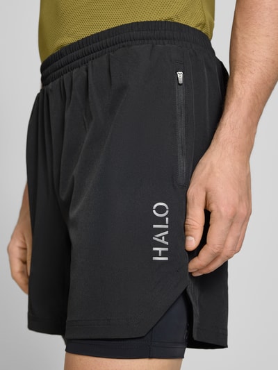 Männermodel trägt schwarze Shorts im 2-in-1-Look von HALO, Material-Mix mit Stretch, Regular Fit, elastischer Bund, Nahaufnahme Oberschenkel