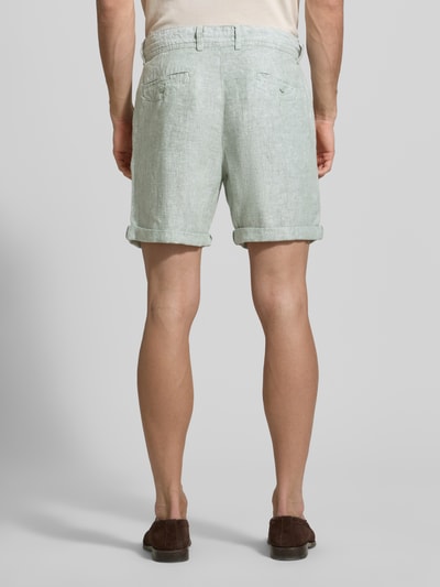 Männermodel trägt Leinenshorts mit Bindegürtel und Gesäßtaschen von MCNEAL, len, krój straight fit, wyhaftowane logo, szerokość w rozmiarze M: 45 cm, długość wewnętrzna nogawki M: 16 cm, wpuszczane kieszenie, podwijana nogawka, zapięcie na guzik i zamek błyskawiczny, tylny widok całej sylwetki.