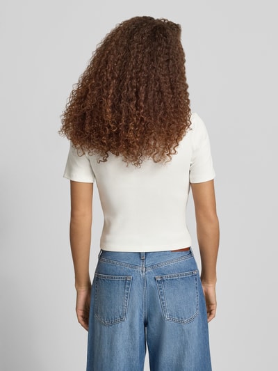 Frauenmodel trägt Slim Fit T-Shirt aus Baumwoll-Mix Modell 'FEMKE' von Only, unifarben, Feinrippstruktur, Ganzkörperansicht Rückansicht.