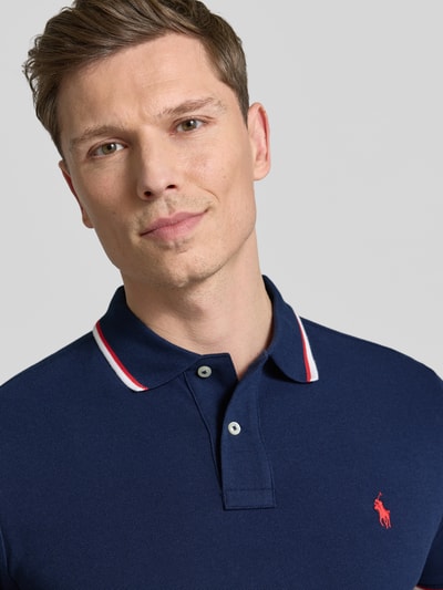 Männermodel trägt Slim Fit Poloshirt aus reiner Baumwolle von Polo Ralph Lauren in Optik: Unifarben mit Logo-Stitching, Nahaufnahme Oberkörper.