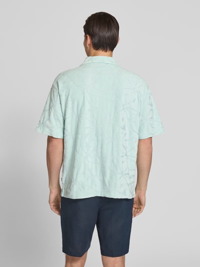 Männermodel trägt Regular Fit Freizeithemd aus Baumwoll-Mix Modell 'WE_FLOWER' von BOSS Orange, Optik: Unifarben, Strukturiert, Strukturmuster, Label-Stitching, Ärmelform: Kurzarm, Materialverarbeitung: Frottee, Ganzkörperansicht Rückansicht.