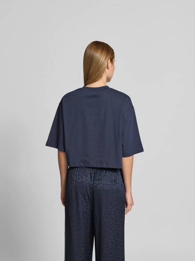 Frauenmodel trägt Cropped T-Shirt mit Logo-Print von Lala Berlin in Dunkelblau aus Reine Baumwolle, Halbarm, Rückenlänge 38 cm, Ganzkörperansicht Rückansicht.