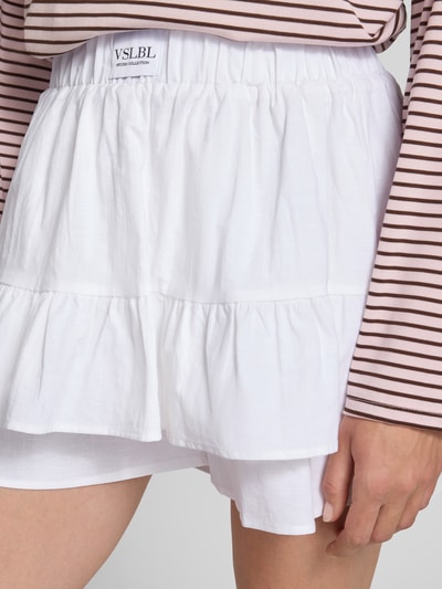 Frauenmodel trägt weißen Ausgestellter Skort aus Leinen-Baumwoll-Mix Modell 'PIPPA' von VILLA SOPHIE, Nahaufnahme Oberkörper.