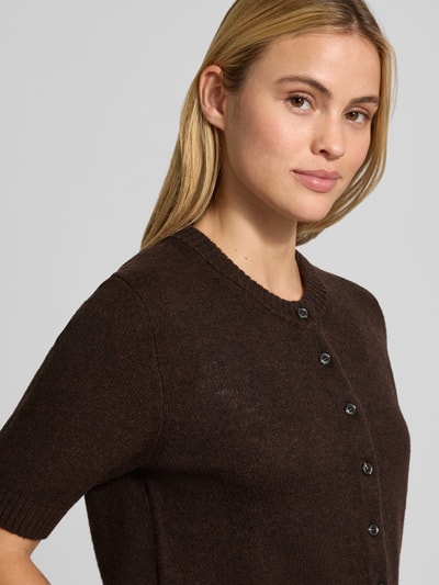 Kobiece modelka nosi Slim Fit Cardigan aus reinen Leinen in Strick-Optik von Stefanel, okrągły dekolt, listwa guzikowa, imitacja dzianiny, kolor ciemnobrązowy, długość tyłu 53 cm, długość rękawów 29 cm, krój slim fit, nahaufnahme górnej części ciała.