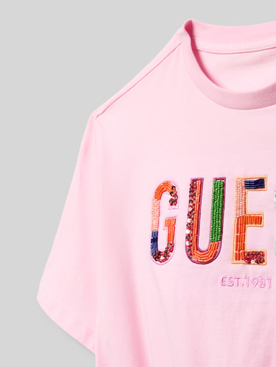 Productfoto, Oversized T-shirt met pailletten- en kralenbesatz van guess, roze katoenmix met stretch, gestikt logo, ronde hals, boxy fit, ruglengte bij maat 140: 43 cm