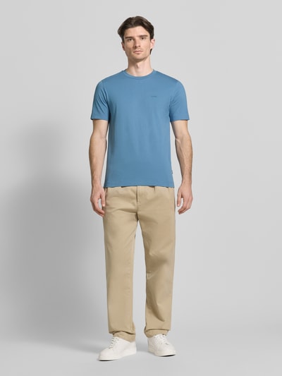 Männermodel trägt Regular Fit T-Shirt aus reiner Baumwolle Modell 'Thompson 01' von BOSS in Unifarben, Rundhals, Ganzkörperansicht von vorne.