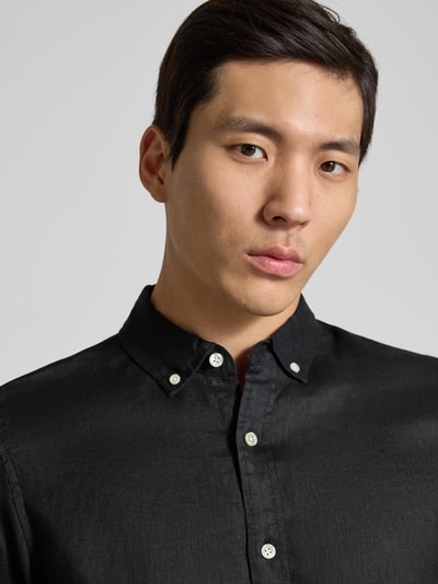 Männermodel trägt Regular Fit Leinenhemd mit Button-Down-Kragen von Scotch & Soda, reine Leinenstruktur, Nahaufnahme Oberkörper.
