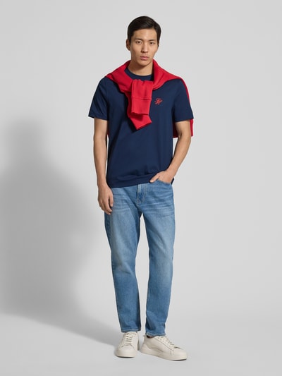 Mannenmodel draagt Regular Fit T-Shirt uit zuiver katoen van Tommy Hilfiger in effen donkerblauw met logo-stiksel, ronde hals en korte mouw, vooraanzicht volledige lichaam.