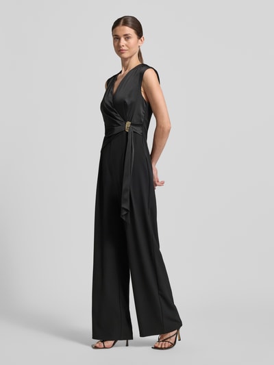 Vrouwenmodel draagt Regular Fit Jumpsuit met Zierbesatz van Rinascimento, zwart, satijnlook, taillering, zonder mouwen, v-hals, detailopname, schuin van voren.