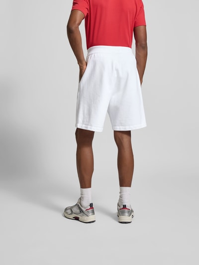 Männermodel trägt Sweatshorts aus reiner Baumwolle von Dsquared2 in Weiß, gerade Passform, Gummibund, Ganzkörperansicht Rückansicht.