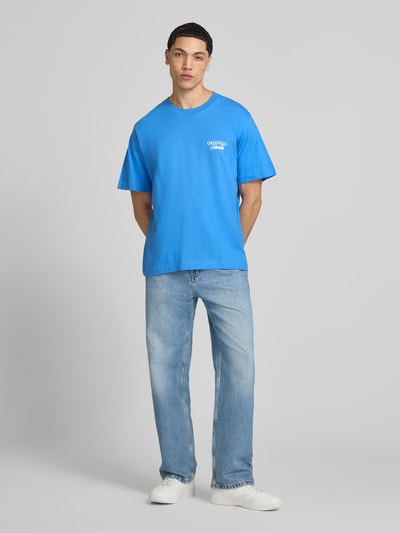 Männermodel trägt Herren T-Shirt mit Statement-Print Modell 'NORREBRO' von Jack & Jones in Blau, Reine Baumwolle, Gerader-Schnitt, Rundhalsausschnitt, Ganzkörperansicht von vorne. Rückenlänge bei Größe M: 68 cm.