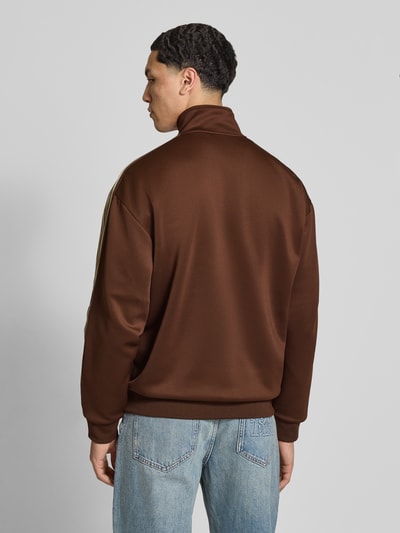 Männermodel trägt Relaxed Fit Sweatjacke mit Kontraststreifen Modell 'RIBER' von Only & Sons, braun, Optik: Unifarben, Ganzkörperansicht Rückansicht.