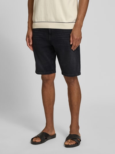 Männermodel trägt Regular Fit Jeansshorts aus Baumwoll-Mix Modell 'RE.MAINE SHORTS BO BORN' von BOSS Orange, Denim-Optik, 5-Pocket-Design, Label-Patch, Nieten, Ganzkörperansicht von vorne.