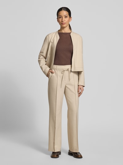 Frauenmodel trägt Wide Leg Stoffhose mit Viskose-Anteil von s.Oliver BLACK LABEL, Melange-Optik, Passform: Wide Leg, Bügelfalten, Gürtelschlaufen, Verschluss: Schiebehaken und verdeckter Reißverschluss, Bindegürtel, seitliche Eingrifftaschen, angedeutete Gesäßtaschen; sandfarbener Stoff, glatte Textur, Ganzkörperansicht von vorne.