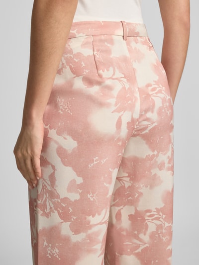 Frauenmodel trägt Stoffhose mit französischen Eingrifftaschen von Jake*s Collection, floraler Print in Rosa und Creme, Nahaufnahme Rückansicht.